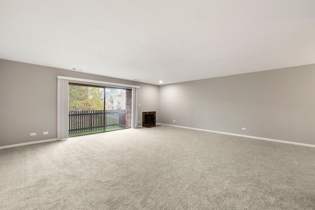 unfurnished living room with carpet flooring and a fireplace