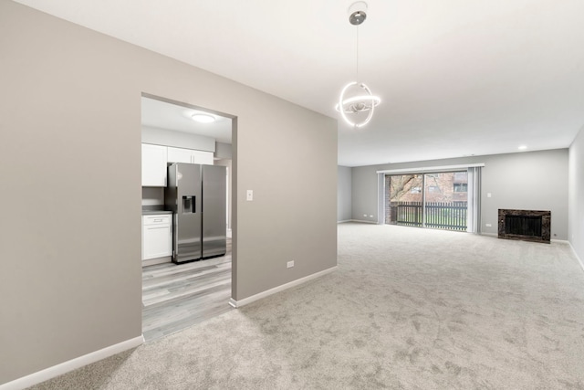 unfurnished living room featuring light colored carpet