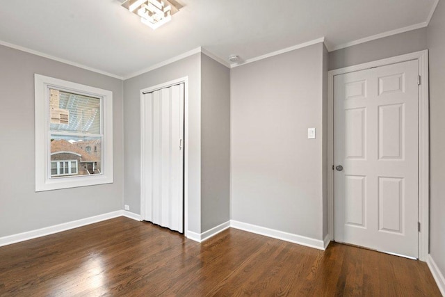 unfurnished bedroom featuring dark hardwood / wood-style floors, ornamental molding, and a closet