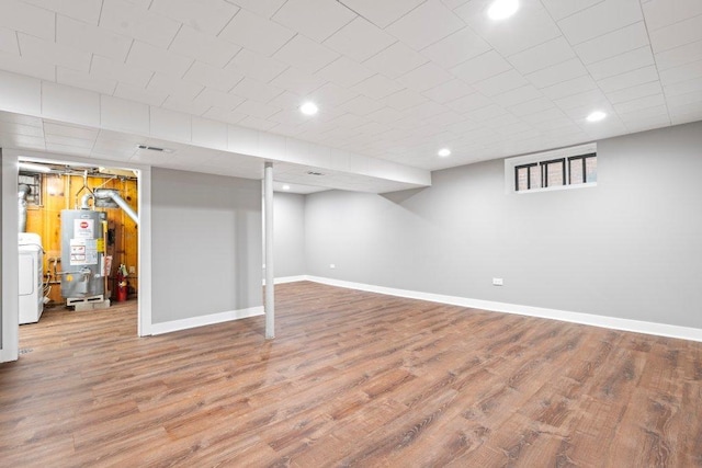 basement with washer / clothes dryer, wood-type flooring, and gas water heater