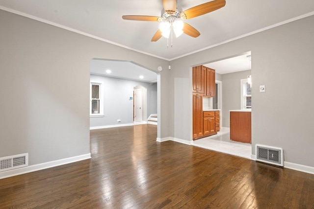 unfurnished living room with ceiling fan, dark hardwood / wood-style flooring, and crown molding