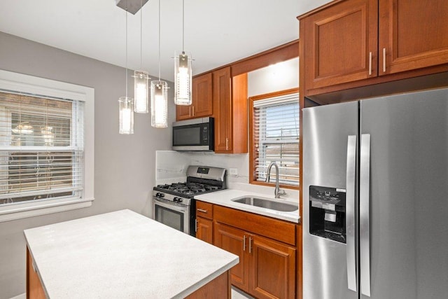 kitchen with hanging light fixtures, a center island, sink, and appliances with stainless steel finishes