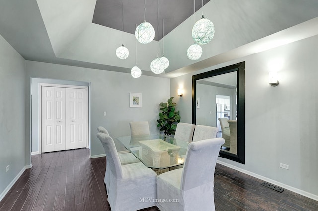 dining area with dark hardwood / wood-style floors and high vaulted ceiling