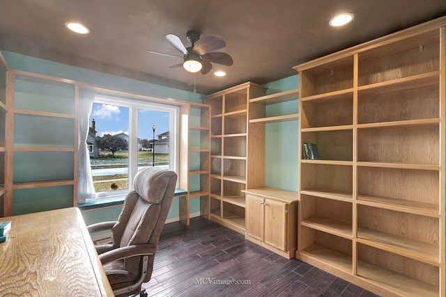 unfurnished office featuring dark hardwood / wood-style flooring, ceiling fan, and a water view