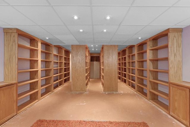 wine area with concrete flooring and a drop ceiling