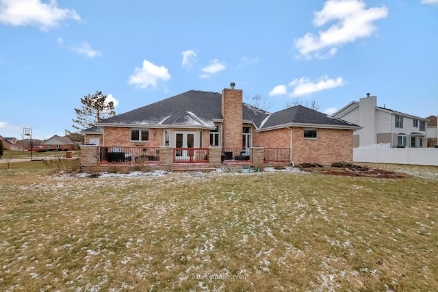 rear view of property with a deck and a lawn