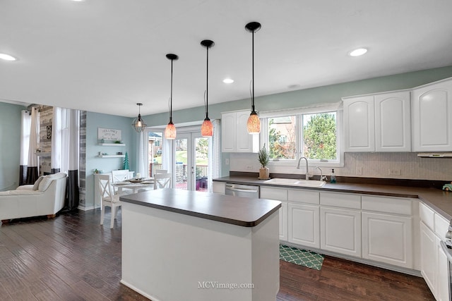 kitchen with white cabinetry, a center island, sink, and decorative light fixtures