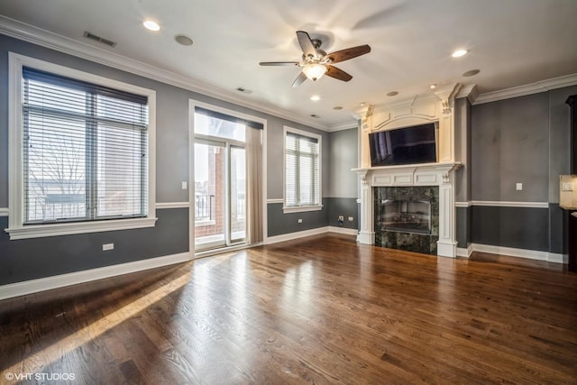 unfurnished living room featuring ceiling fan, a high end fireplace, ornamental molding, and hardwood / wood-style floors