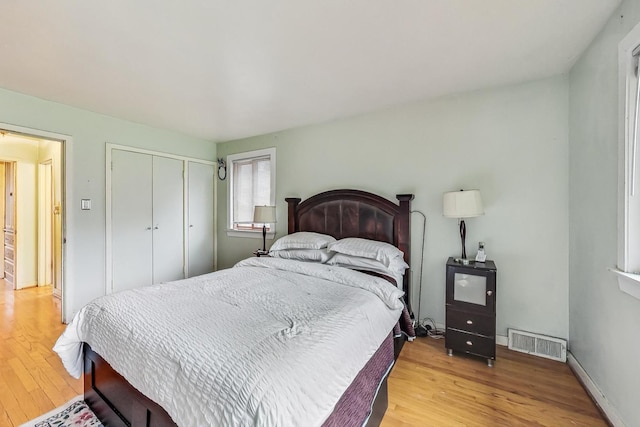 bedroom with light hardwood / wood-style flooring and a closet