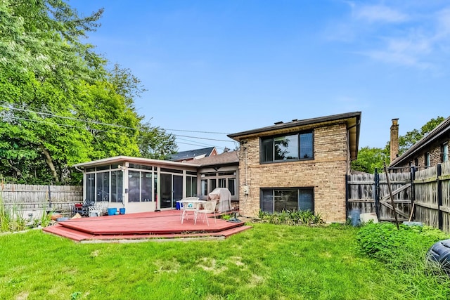 back of property featuring a lawn, a sunroom, and a deck