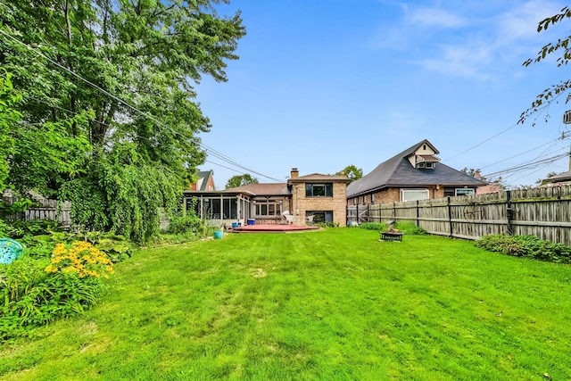 view of yard featuring a sunroom and a wooden deck