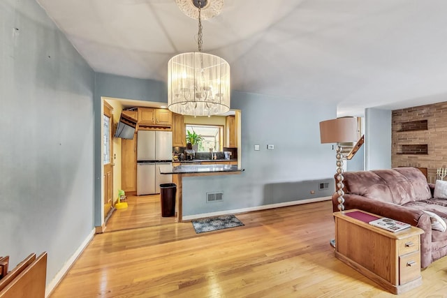 living room featuring light hardwood / wood-style flooring and an inviting chandelier