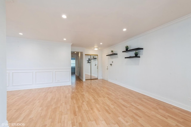 spare room featuring light wood-type flooring and ornamental molding