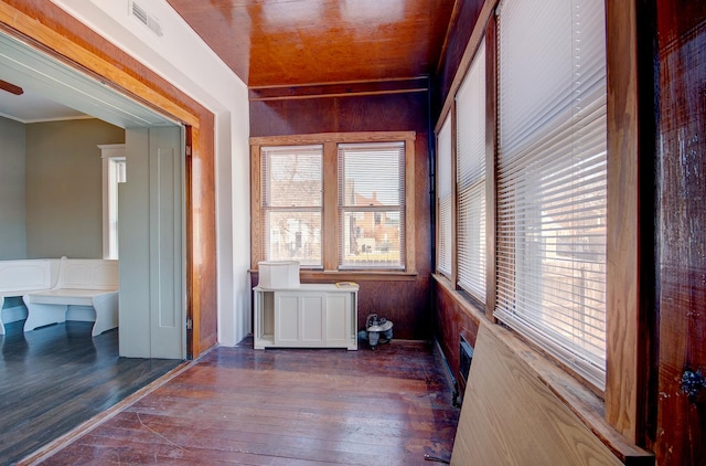 interior space featuring wooden walls and dark hardwood / wood-style flooring