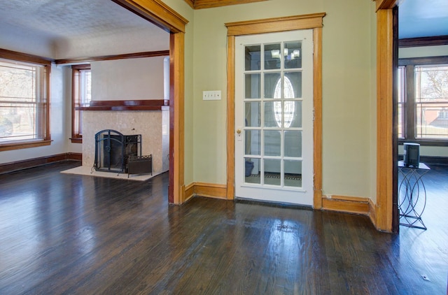 doorway to outside with a textured ceiling, plenty of natural light, dark hardwood / wood-style floors, and ornamental molding