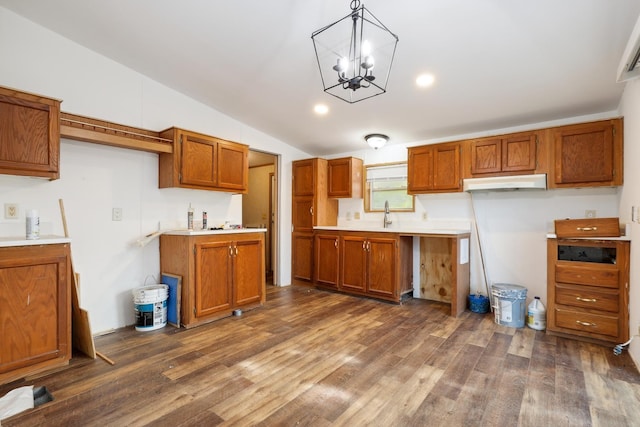 kitchen with pendant lighting, sink, vaulted ceiling, dark hardwood / wood-style flooring, and a chandelier