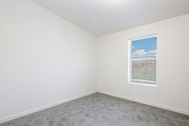 empty room with lofted ceiling and light carpet