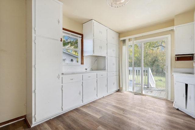 kitchen with light hardwood / wood-style flooring and white cabinets