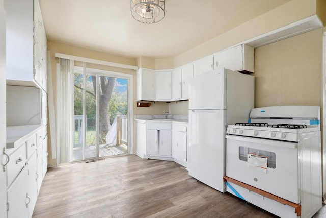 kitchen with light hardwood / wood-style floors, white cabinetry, white appliances, and sink