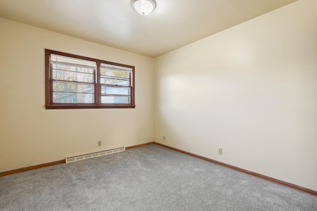 carpeted empty room featuring baseboard heating