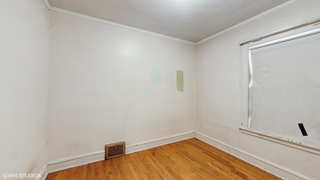 empty room featuring hardwood / wood-style flooring and ornamental molding