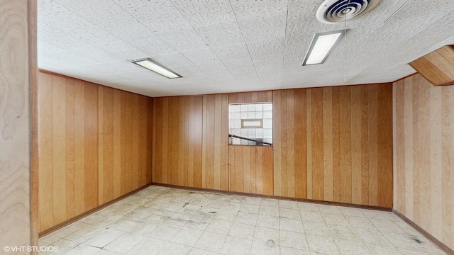 unfurnished room with wood walls