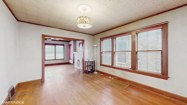 unfurnished room with hardwood / wood-style floors and crown molding