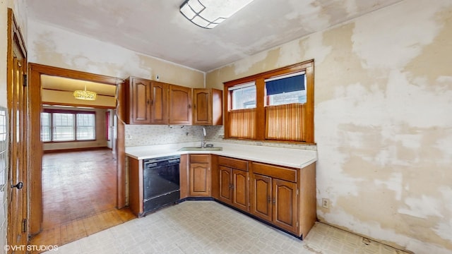 kitchen featuring sink, black dishwasher, and tasteful backsplash