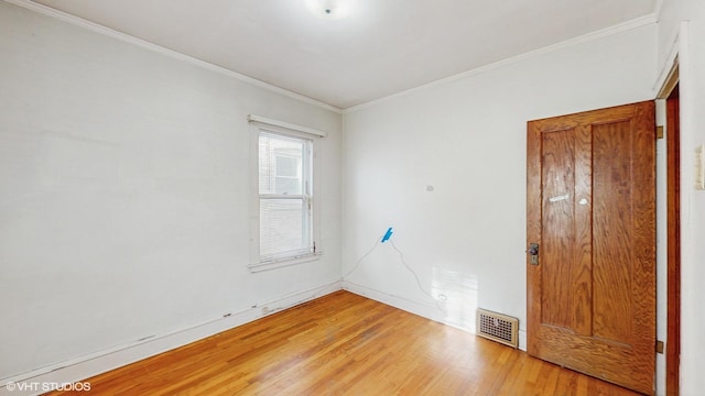 empty room with hardwood / wood-style flooring and ornamental molding