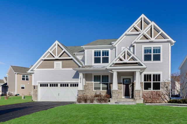 craftsman house with stone siding, driveway, and a front yard