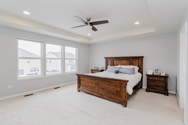 bedroom with visible vents, a raised ceiling, and baseboards