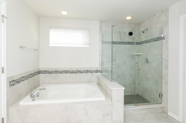 bathroom featuring a stall shower and a garden tub