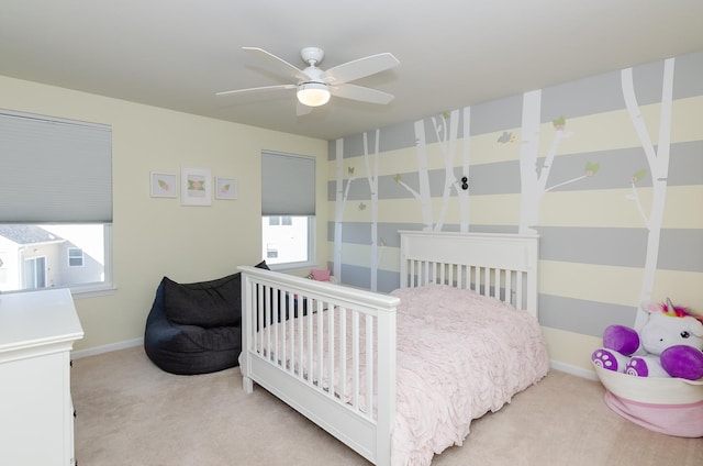 bedroom featuring light colored carpet, baseboards, and ceiling fan