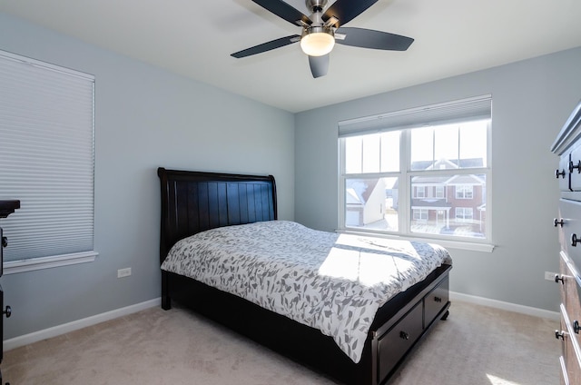 bedroom featuring light colored carpet, baseboards, and ceiling fan