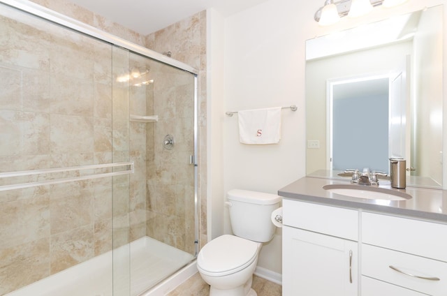 bathroom with a shower stall, toilet, and vanity