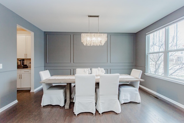 dining room with visible vents, baseboards, dark wood finished floors, an inviting chandelier, and a decorative wall