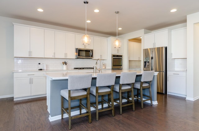 kitchen featuring white cabinets, stainless steel appliances, and dark wood-type flooring