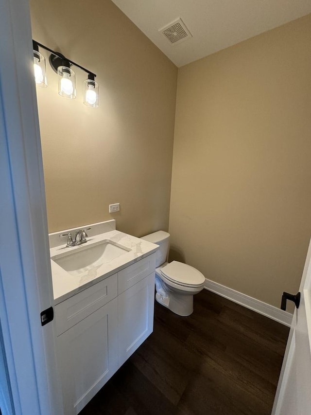 bathroom featuring vanity, toilet, and wood-type flooring