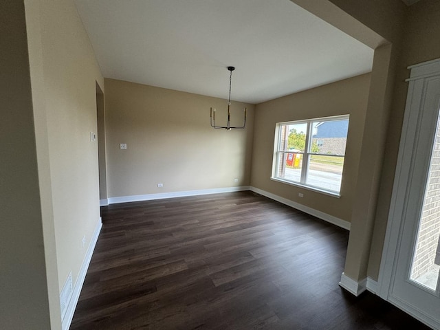 unfurnished dining area featuring dark wood-type flooring and a chandelier