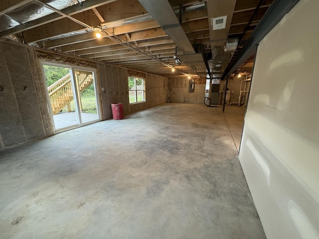 basement with a healthy amount of sunlight and heating unit