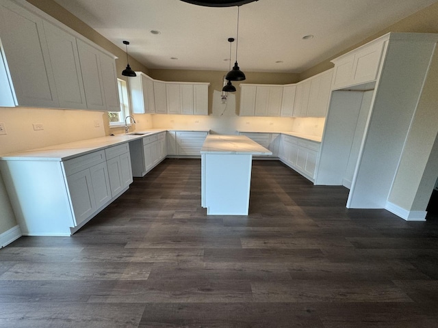 kitchen featuring dark hardwood / wood-style flooring, a center island, white cabinets, and sink