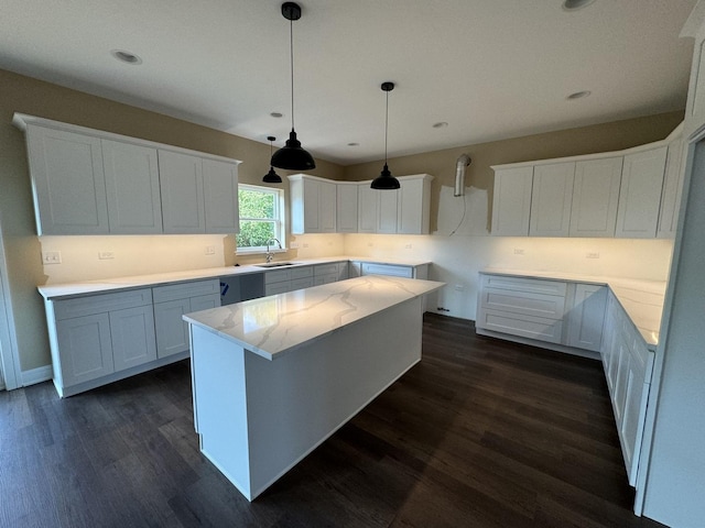 kitchen featuring white cabinetry, a center island, pendant lighting, and dark hardwood / wood-style floors