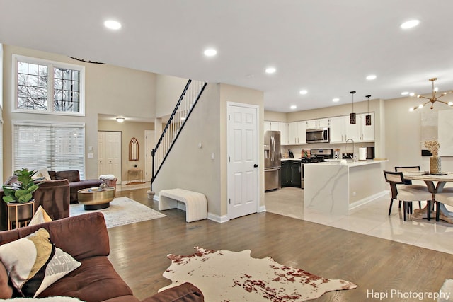 living room with a chandelier, sink, and light hardwood / wood-style floors