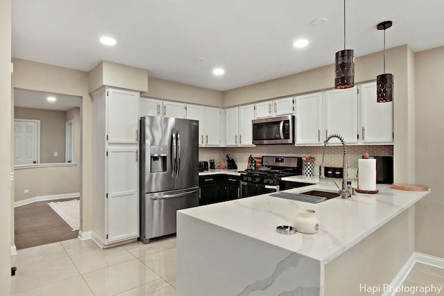 kitchen featuring white cabinetry, hanging light fixtures, stainless steel appliances, tasteful backsplash, and light tile patterned flooring