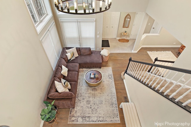 tiled living room with a high ceiling and an inviting chandelier