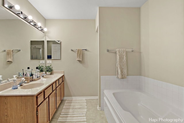 bathroom with tile patterned floors, a bathtub, and vanity