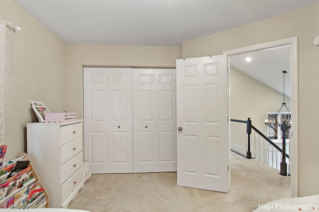 carpeted bedroom with a closet and a chandelier