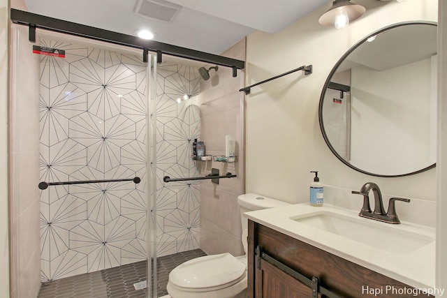 bathroom with vanity, a shower with shower door, and toilet