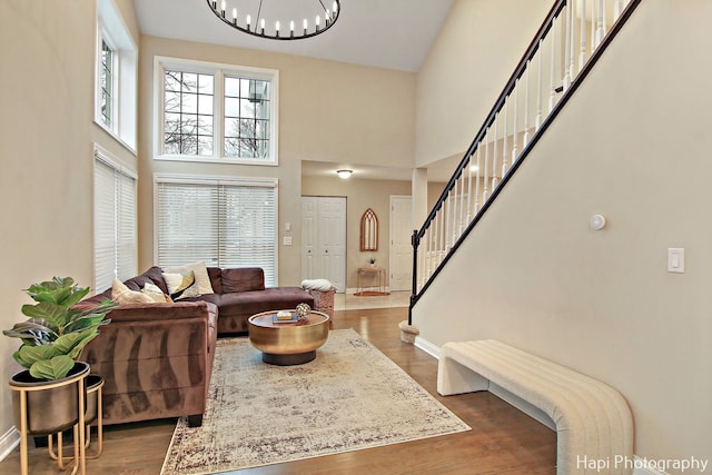 living room with a towering ceiling and dark wood-type flooring