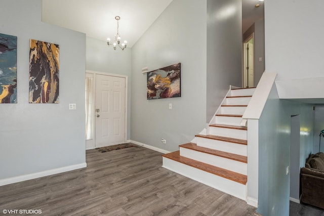 entryway featuring dark hardwood / wood-style flooring, high vaulted ceiling, and an inviting chandelier